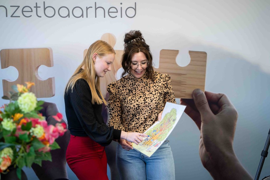 Twee vrouwen bekijken kleurrijke tekening en puzzelstuk.